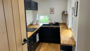 a kitchen with black cabinets and a sink at Builth wells stay in Builth Wells