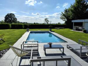 a swimming pool with two chairs and a table at Fabiche in Verviers