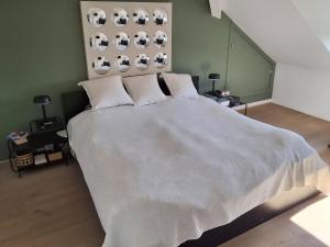 a bedroom with a large bed with white sheets at Fabiche in Verviers