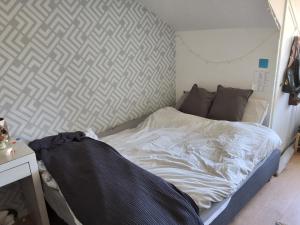an unmade bed in a room with a wall at Fabiche in Verviers
