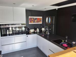 a kitchen with white cabinets and a black counter top at Fabiche in Verviers