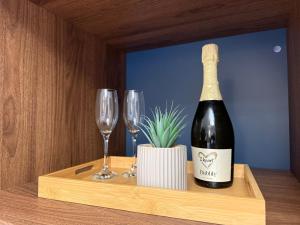 a bottle of wine and two wine glasses on a shelf at All Seasons Guesthouse in Belfast