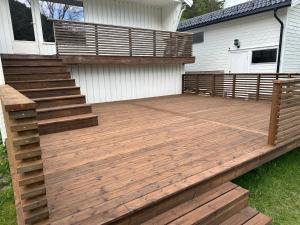 a wooden deck with stairs next to a house at Bolig leies ut med 3 soverom in Namsos +2 photos