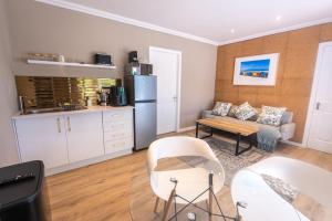 a kitchen and living room with a couch and a table at The Palm Suites in Meadowridge