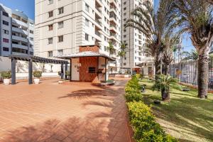 a courtyard with a building and palm trees and buildings at Apto com conforto que você precisa. in Goiânia