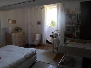 a child sitting in a chair in a bedroom at Chez Julia in Puycelci