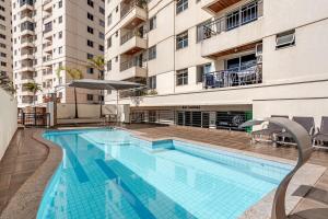 a large swimming pool in front of a building at Apto com conforto que você precisa. in Goiânia