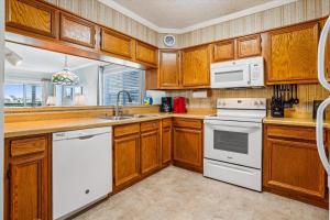 a kitchen with wooden cabinets and white appliances at Duck Legacy Unit 2E in Duck
