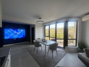 a living room with a table and a large tv at View of the forest in Veliko Tŭrnovo