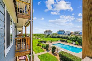 a balcony with a view of a pool and yard at Duck Legacy Unit 2E in Duck