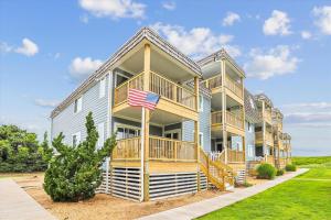 a large apartment building with an american flag in front at Duck Legacy Unit 2E in Duck