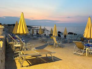 a group of chairs and umbrellas on a beach at Riva Sweet Home in Giovinazzo