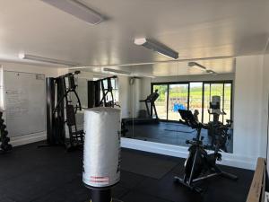 a gym with treadmills and exercise equipment in a room at Modern 2 bed home in idyllic location sleeps 6 Superfast WiFi with onsite Gym in Stagsden