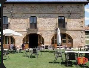 a building with tables and chairs in front of it at Nuestra Señora de Revenga in Regumiel de la Sierra