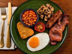 a green plate of food with eggs bacon beans and toast at The Mariners - Torquay in Torquay