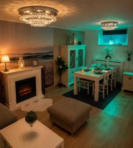ein Wohnzimmer mit einem Tisch und einem Kamin in der Unterkunft Ferienwohnung Lakeside in Heiligenhafen