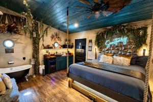 a bedroom with a bed and a tub and a sink at "Tree-T-Ment Center" Spa-Themed Luxury Treehouse with Indoor & Outdoor Soaking Tubs in Sevierville