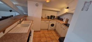 a kitchen with a sink and a washing machine at APPARTEMENT T2 proche de l'océan in Capbreton