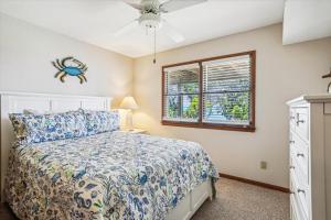 a bedroom with a bed and a window at Emerald Duck in Duck