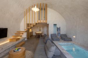 a living room with a swimming pool and a house at Santorini Soul Villas in Pyrgos