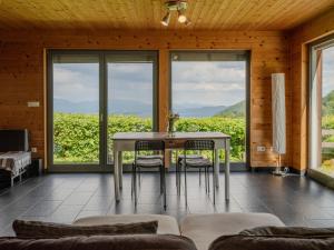 a dining room with a table and chairs and windows at St Barbara Hideaway in Škofja Loka