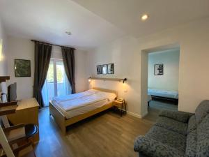ein Schlafzimmer mit einem Bett, einer Couch und einem Stuhl in der Unterkunft Hotel Alberello - Varone in Riva del Garda + 32 Fotos