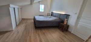 a bedroom with a bed and a wooden floor at APPARTEMENT T2 proche de l'océan in Capbreton