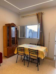 a dining room with a table and chairs and a window at Dar Samir in Awlād ‘Umar