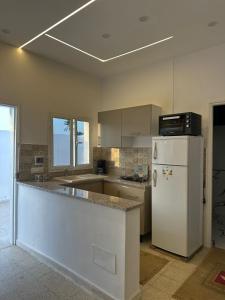 a kitchen with a white refrigerator and a counter at Dar Samir in Awlād ‘Umar