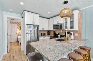 a kitchen with white cabinets and a granite counter top at Island Vibes House in Clearwater Beach +21 photos