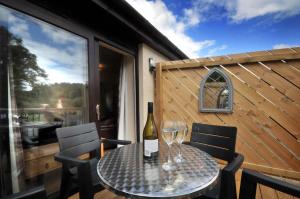 una mesa con una botella de vino y dos copas en Tarven Self Catering cottages en Portree