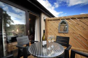 a table with a bottle of wine and two glasses at Tarven Self Catering cottages in Portree
