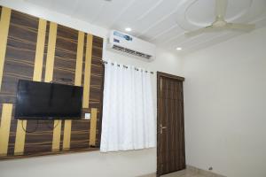 a room with a flat screen tv and a door at Hotel SR Siddhivinayak Mathura in Mathura +20 photos