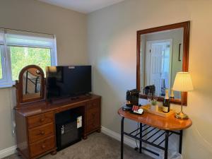 a room with a television and a table with a mirror at All Seasons Guesthouse in Belfast +111 photos