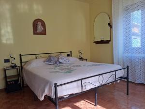 a bed in a bedroom with a mirror and a window at Dai Barèta in Dare