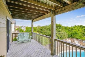 a porch with a rocking chair on a wooden deck at Duck Views in Duck