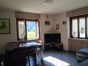 a living room with a table and a television at Dai Barèta in Dare