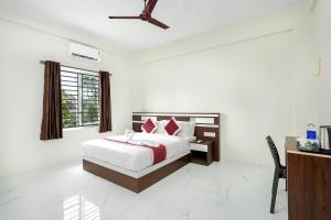 a bedroom with a bed and a desk and a window at Hotel Livora in Alwaye +46 photos
