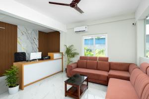a living room with a couch and a tv at Hotel Livora in Alwaye