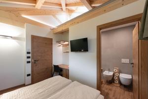 a bedroom with a bed and a sink and a tv at Palazzo Tamanini in Calceranica al Lago