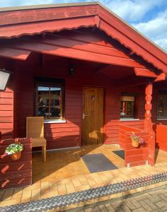 a red house with a red roof with a patio at Gasthaus Goa in Ernsthausen