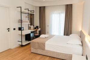 a bedroom with a bed and a desk in it at JB Hotel in Sarandë +55 photos