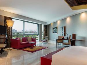 a hotel room with a bed and a living room at The Creekside Hotel, Dubai - an Accor Hotel in Dubai