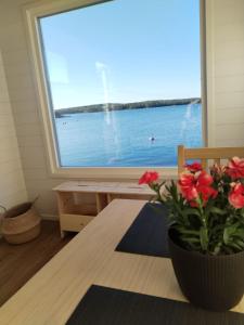 a room with a table and a window with a view of the water at Your cottege by the sea in Saltvik +9 photos