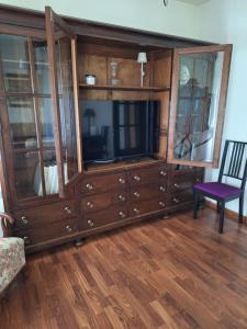 a large wooden entertainment center with a tv and a chair at Turística Cervantes 1 in Priego de Córdoba