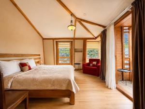a bedroom with a bed and a red chair at Hotel Old Seti in Mestia