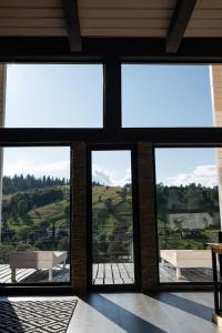 a room with four windows with a view of a field at Horizon Славсько з чаном,басейном in Khashchovanoye