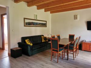 a living room with a black couch and a table at Noclegi u Gosi w Polańczyku in Polańczyk