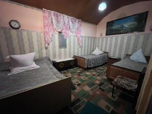 a bedroom with two beds and a clock on the wall at уют in Cholpon-Ata +10 photos