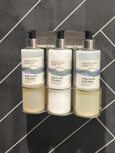 a group of three bottles of soap on a shelf at Strathmore Guest house in Fort William +34 photos